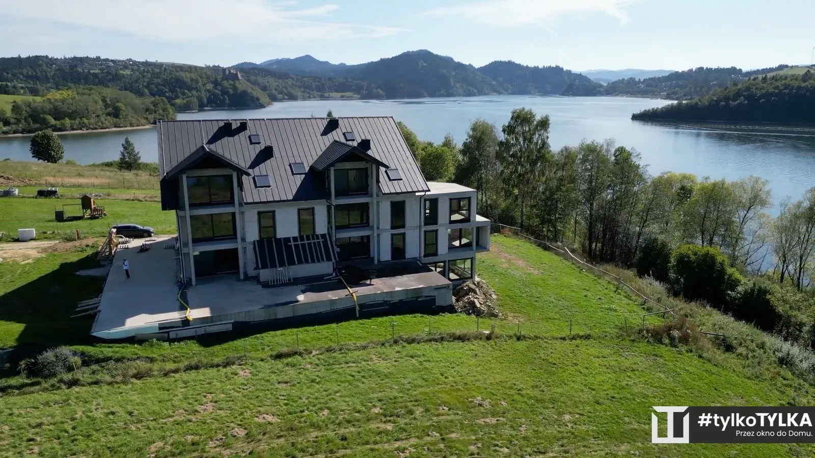 Apartamentowiec nad jeziorem, w tle zamek i Pieniny