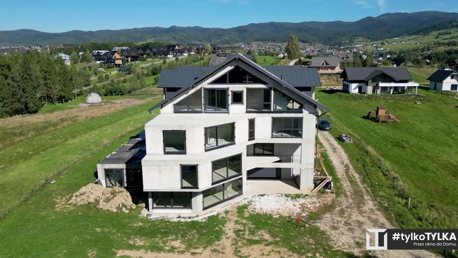 Apartamentowiec na tle panoramy Podhala i gór