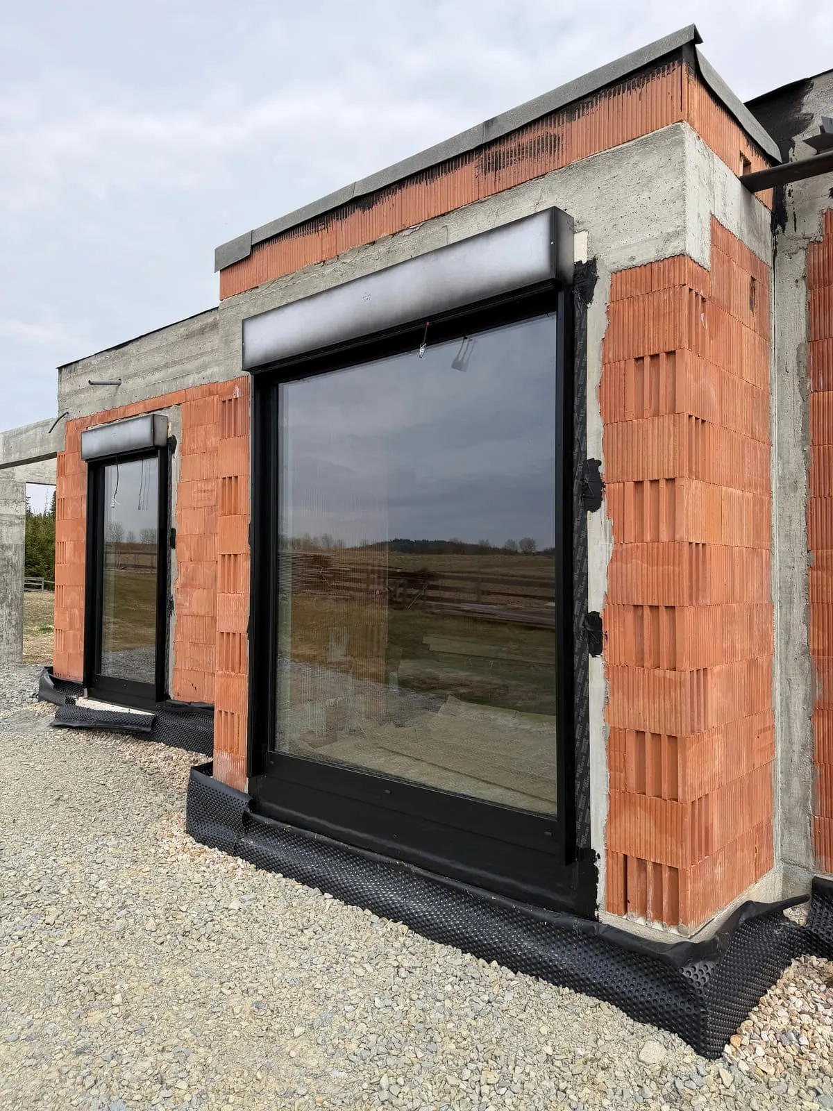 Parterowa część domu z dużymi przeszkleniami w czarnym aluminium
